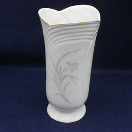 White ceramic vase with floral design on a dark blue background