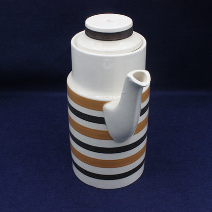 Ceramic pitcher with striped design on a dark blue background