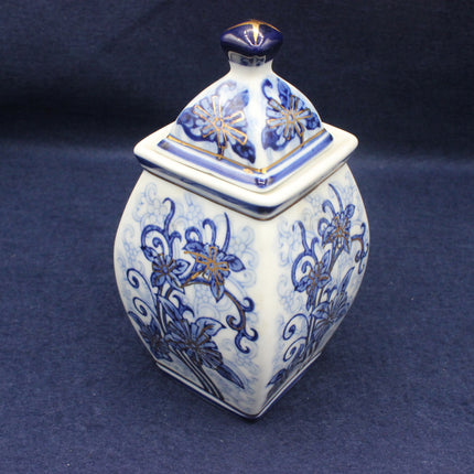 Decorative ceramic jar with blue floral patterns on a dark background