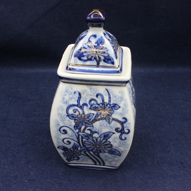 Blue and white ceramic jar with floral patterns on a dark blue background
