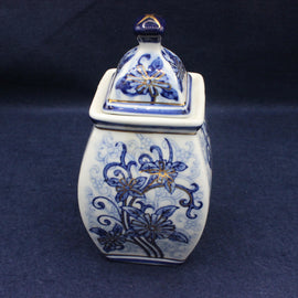 Blue and white ceramic jar with floral patterns on a dark blue background