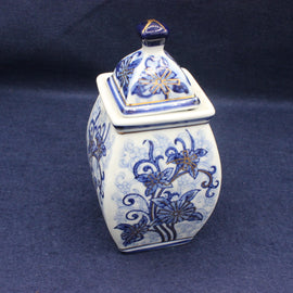 Blue and white ceramic jar with floral patterns on a dark blue background