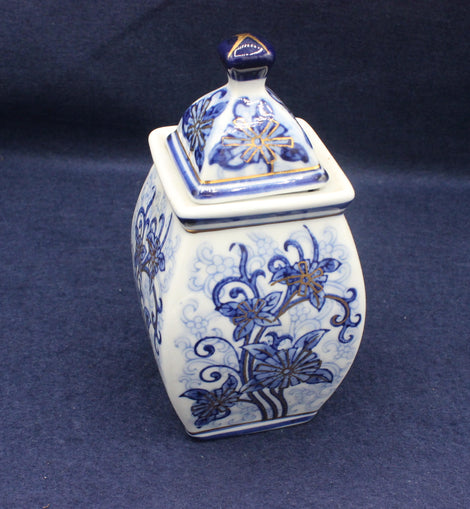 Blue and white ceramic jar with floral patterns on a dark blue background