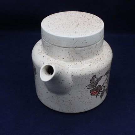 Ceramic teapot with floral design on a dark blue background