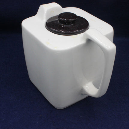 White plastic container with black cap on a dark blue background
