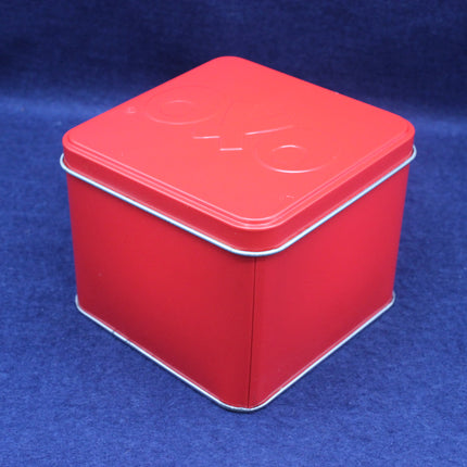 Red square tin box with a white logo on a blue background