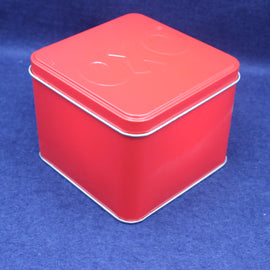 Red square tin box with a lid on a blue background