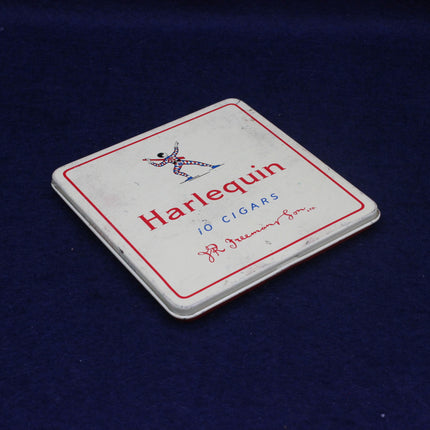 Harlequin cigar tin on a dark blue background