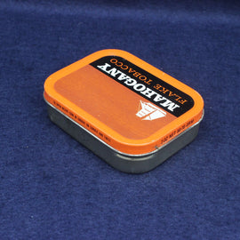 Tin of Flakiq Toracoco Mahogany on a blue background