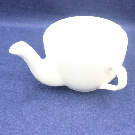 White ceramic teapot on a blue background