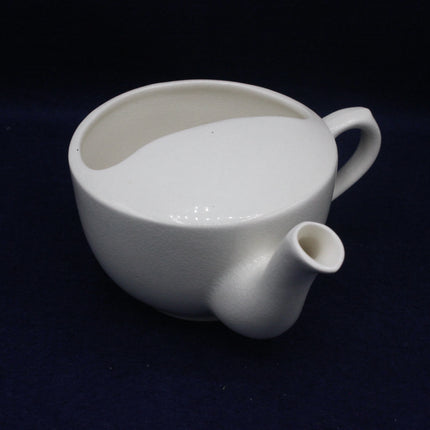 White ceramic pitcher on a dark background