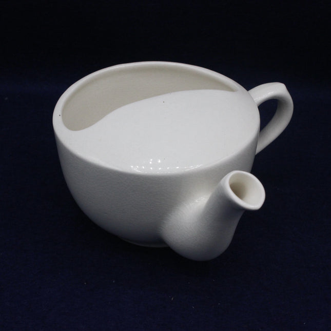 White ceramic pitcher on a dark background