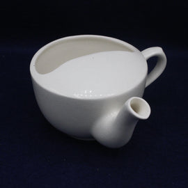 White ceramic pitcher on a dark background