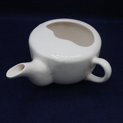 White ceramic teapot on a dark blue background