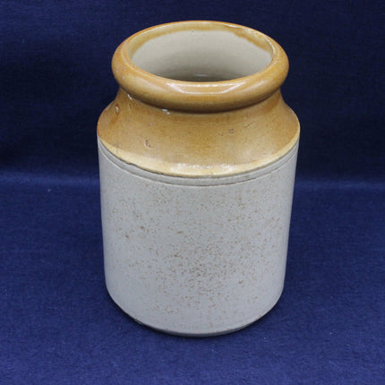 Ceramic jar with brown top and gray body on a blue background