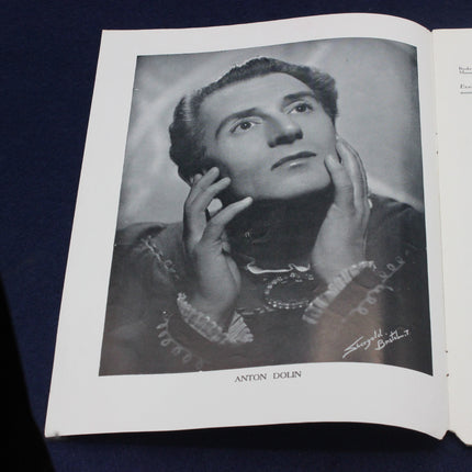 Open book with a black and white portrait of Anton Dolin on a dark background