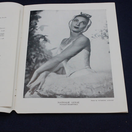 Black and white photograph of a dancer in a tutu sitting outdoors, with text on a book page.