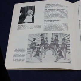 Open book with black and white illustration of dancers and text on a dark background