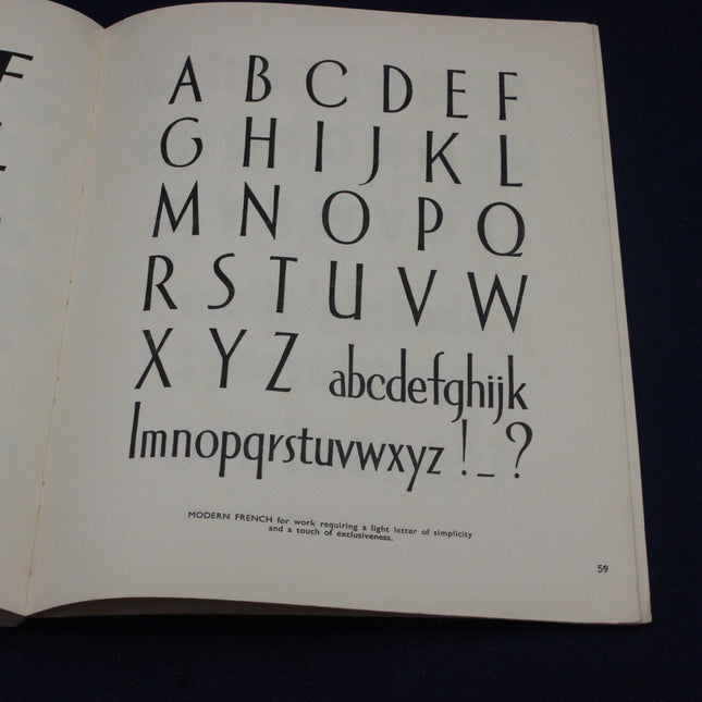 Open book displaying a typographic display of the alphabet on a white page.