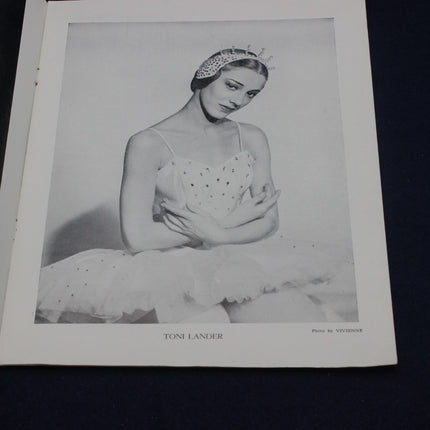 Black and white photograph of a woman in a dress with a tiara, framed by a white border.
