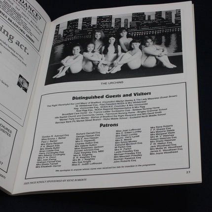 Open book with a black and white photo of a group of women and text on a dark background