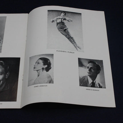 Open book with black and white photographs of people on a dark background