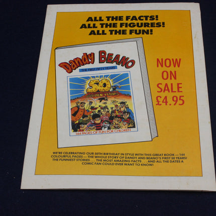 Advertisement for Dandy Beano book with colorful cover and text on a yellow background