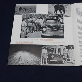 Open book with black and white photographs of people, a car, and animals on a dark background