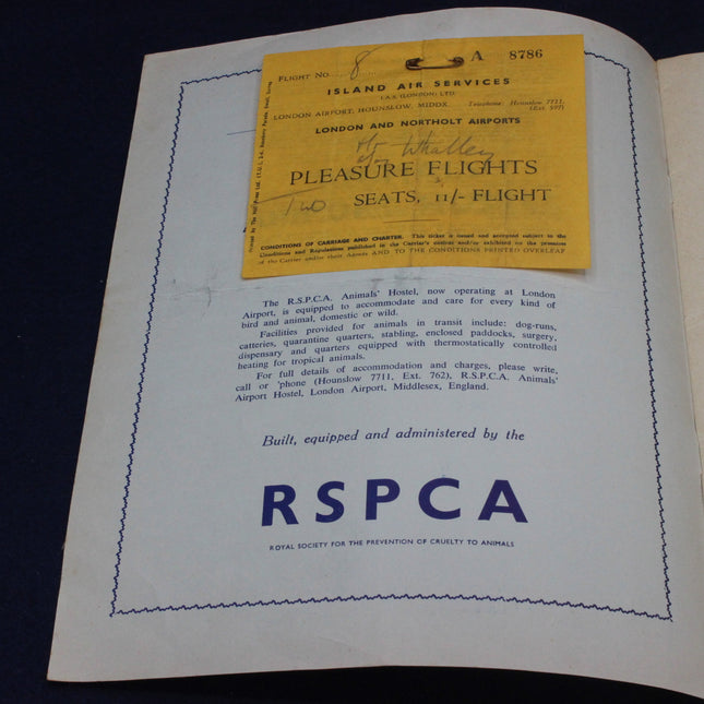 Open book with a yellow air ticket label on a dark background