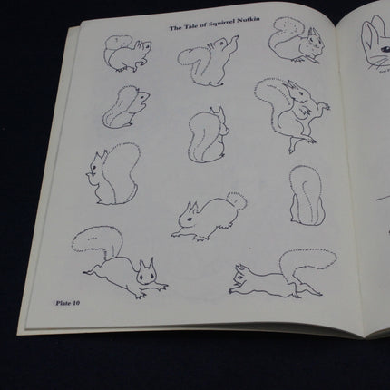 Open book with illustrations of squirrels on a black background