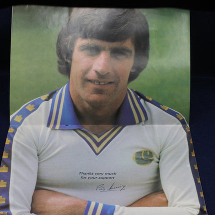 Person wearing a sports jersey with a signature and text, against a green background