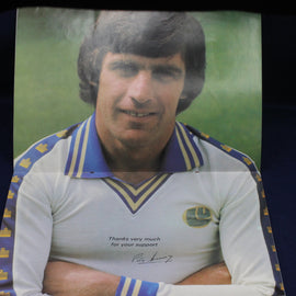 Person wearing a sports jersey with a signature and text, against a green background