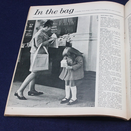 Open book with a black and white photo of a woman and child with bags, on a blue background.