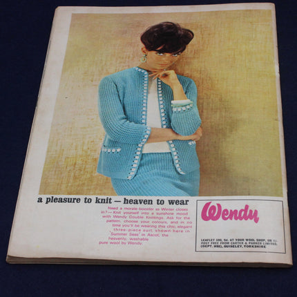 Vintage advertisement for a blue knitted outfit with a woman wearing it, featuring the brand 'Wendy'.