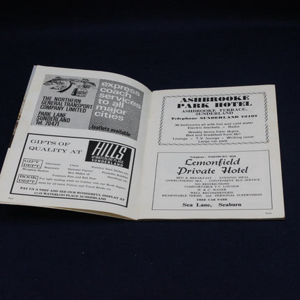 Open book with vintage advertisements on a dark background