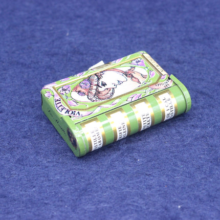 Green and white striped candy box with a floral violet design on a blue background