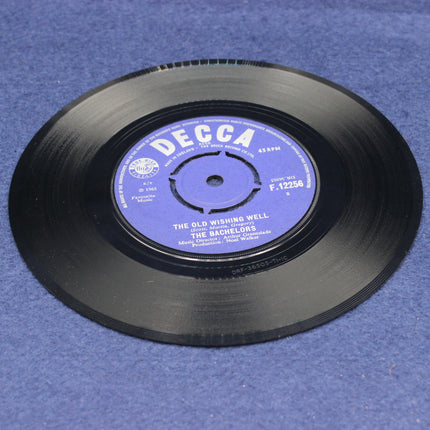 Black vinyl record with a purple label on a blue background
