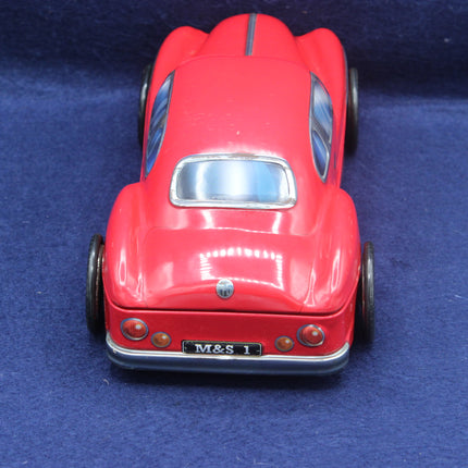 Red toy car with 'M&S' branding on a blue background