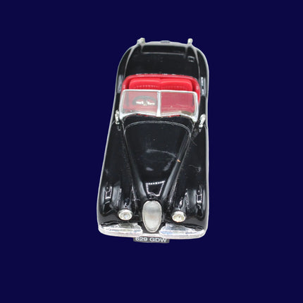 Black model car with red interior on a white background