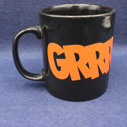 Black mug with orange text on a blue background