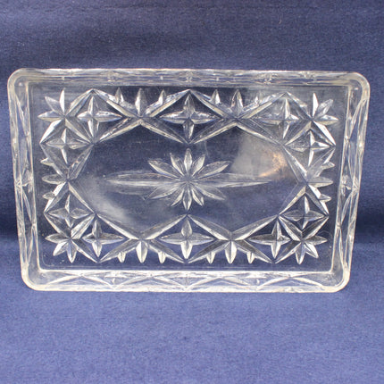 Clear glass dish with star patterns on a blue background