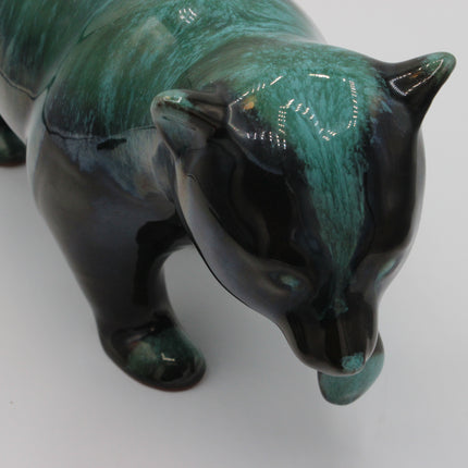 A glossy ceramic figurine of a bear with a marbled green and black glaze, shown on a plain light gray background.