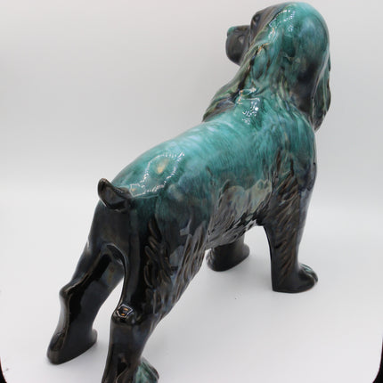 A glazed ceramic figurine of a dog standing on a white studio background.