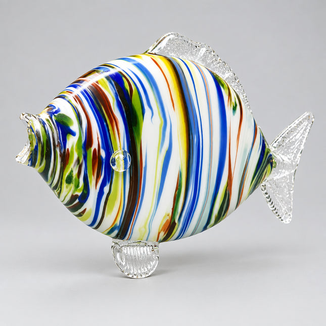 A hand-blown glass fish figurine with vibrant multicolored swirls of blue, purple, green, yellow, and brown on a clear glass base, set against a bright green background.