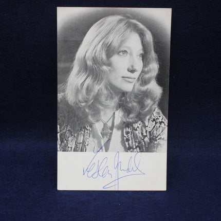 Black and white photo of Leslie Judd with a signature below on a dark background