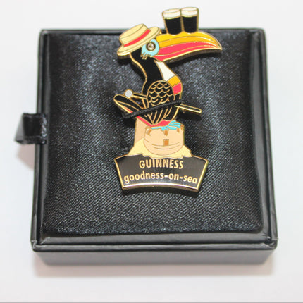Colorful toucan pin with a Guinness beer label on a black display box