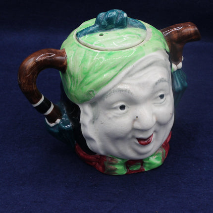 Ceramic teapot with a face design on a blue background