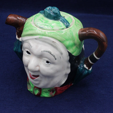 Ceramic teapot with face design on a blue background