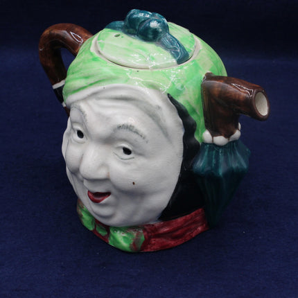 Ceramic teapot with a face design on a dark blue background