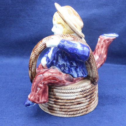 Ceramic teapot with a decorative sailor design on a blue background